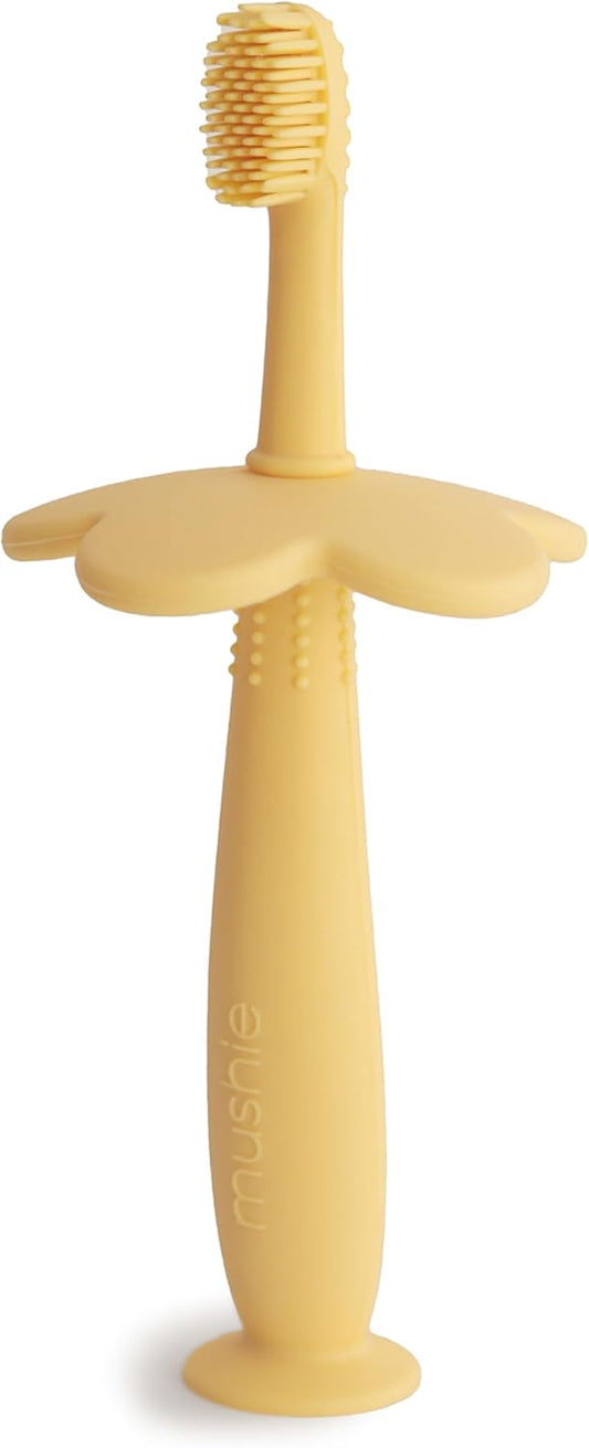 Mushie Escova de dentes de treinamento em silicone, para bebês e crianças pequenas, com base de sucção para fácil armazenamento e treinamento, material: silicone de qualidade alimentar, design de flor (narciso claro).