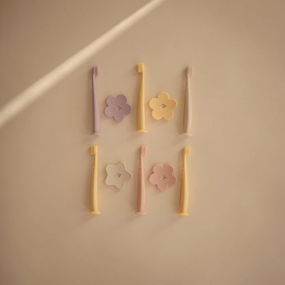 Mushie Escova de dentes de treinamento em silicone, para bebês e crianças pequenas, com base de sucção para fácil armazenamento e treinamento, material: silicone de qualidade alimentar, design de flor