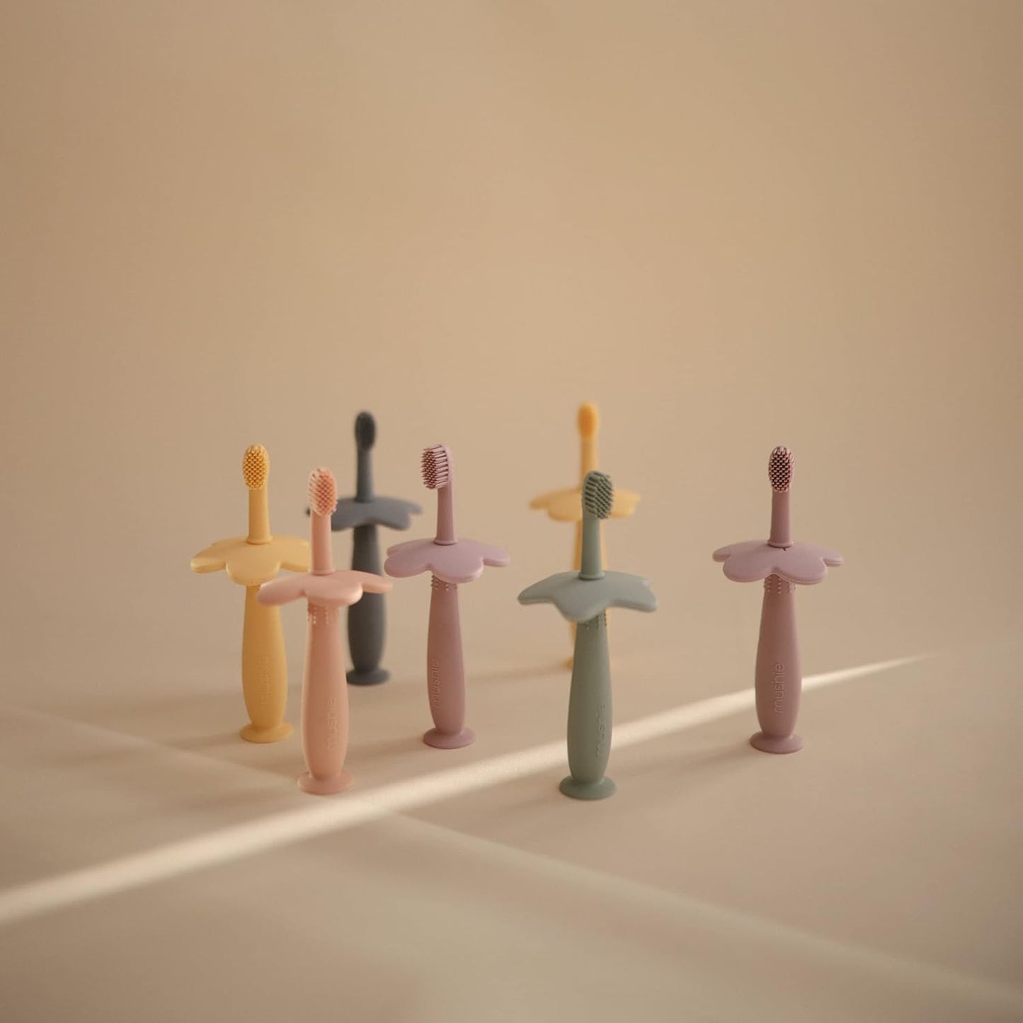 Mushie Escova de dentes de treinamento em silicone, para bebês e crianças pequenas, com base de sucção para fácil armazenamento e treinamento, material: silicone de qualidade alimentar, design de flor (narciso claro).
