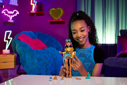 Monster High Boneca Cleo De Nile com blusa dourada e saia em camadas, inclui cobra de estimação Hissette e acessórios como mochila, lanche e pergaminho, HXH74