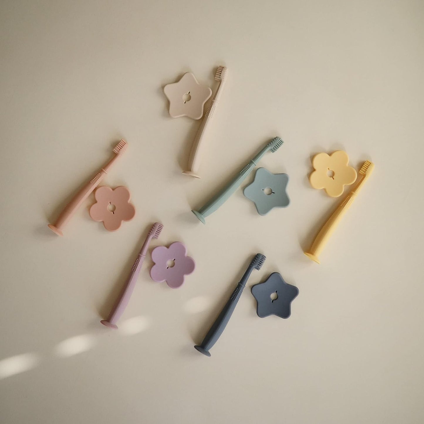 Mushie Escova de dentes de treinamento em silicone, para bebês e crianças pequenas, com base de sucção para fácil armazenamento e treinamento, material: silicone de qualidade alimentar, design de estrela (areia movediça).