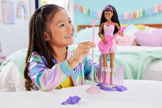 Muñeca Barbie del 65.º aniversario y 10 accesorios, set de estrella pop con muñeca cantante morena, escenario con función de movimiento y más, HRG43