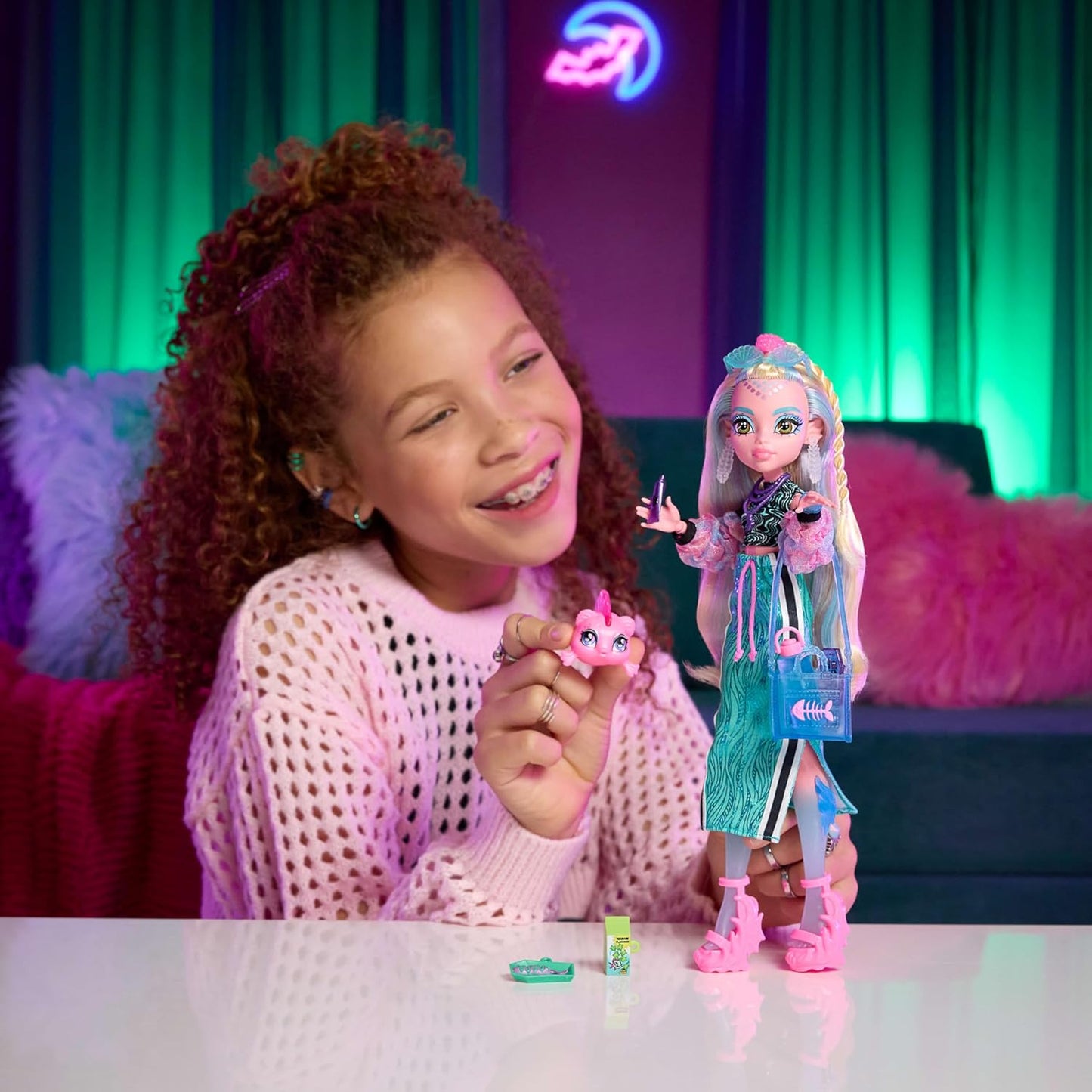 Monster High Boneca Lagoona Blue, com top cropped e saia maxi esportiva, acompanhada de seu peixinho de estimação Neptuna e 7 acessórios como óculos de sol em formato de concha, lanche e bolsa. JHK33
