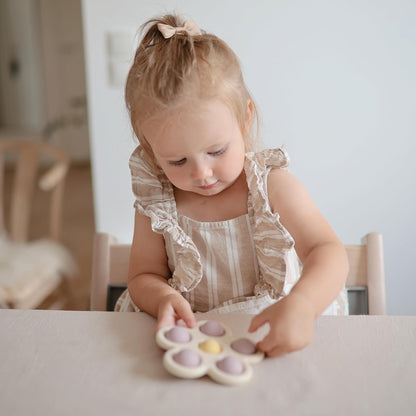 Mushie Brinquedo de apertar | Brinquedo sensorial antiestresse com bolhas | A partir de 10 meses | Brinquedo para aliviar o estresse | 100% silicone de qualidade alimentar e plástico ABS | Design de flor (lilás suave/narciso claro/marfim)