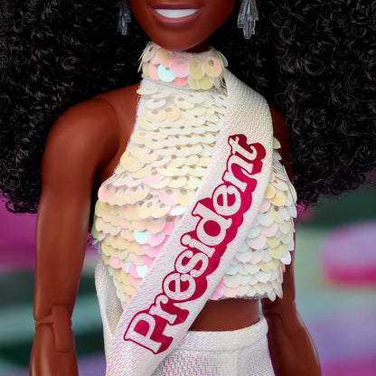 Barbie O Filme - Boneca Colecionável Presidente, Issa Rae como Presidente vestindo blusa branca brilhante e conjunto de shorts, com cabelo cacheado escuro e faixa presidencial, JBJ55